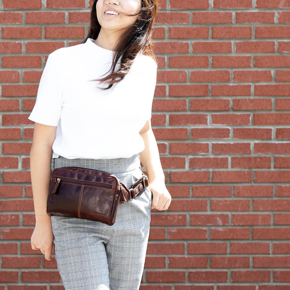 Jack Georges Voyager Brown Large Travel Belt Bag #7109 (Female Model Lifestyle - Front Left Side - brick wall)